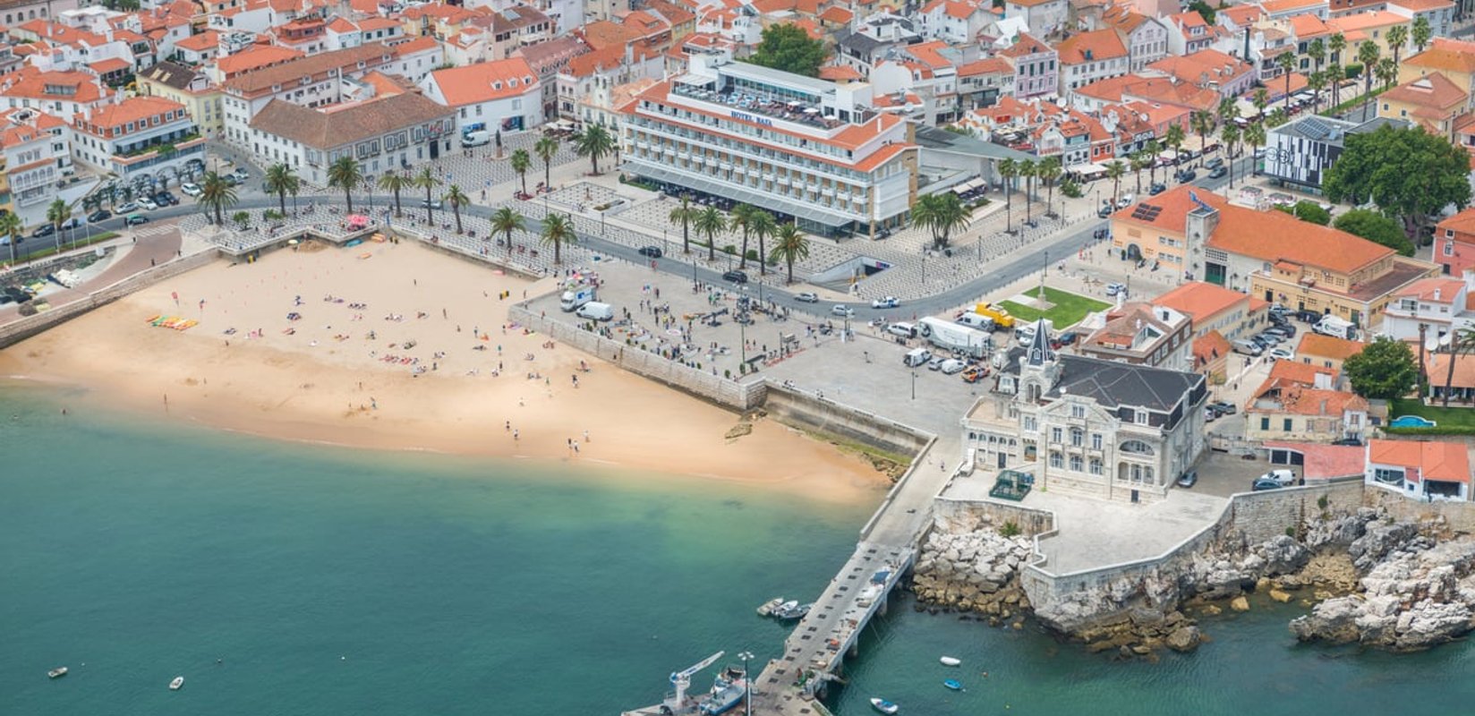 The beach, promenade and pier in the centre of Cascais from above