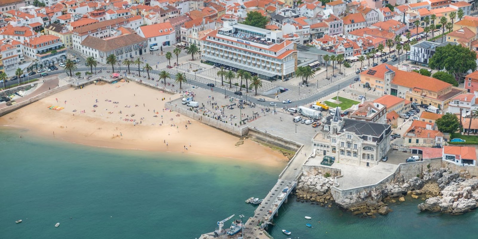 The beach, promenade and pier in the centre of Cascais from above