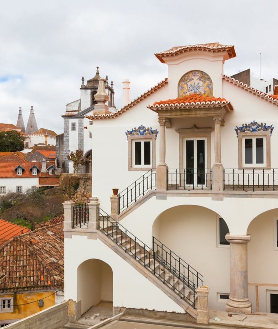 A white villa with painted azulejo panels above the rooftops of Sintra